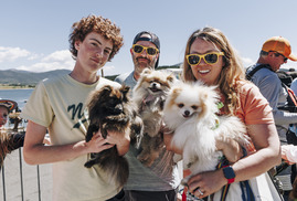 People holding three small dogs