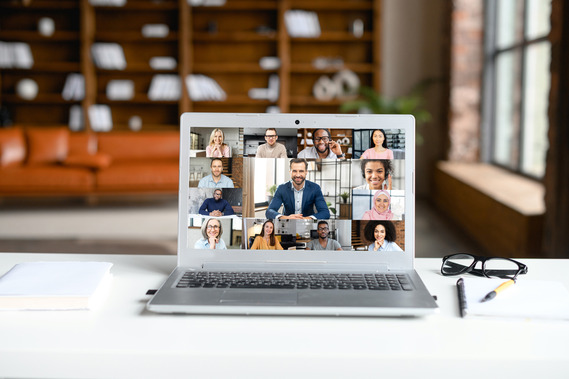 Open laptop on a table with a gallery view of participants on a virtual meeting