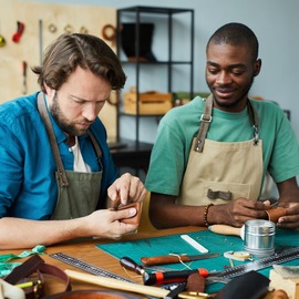 Two men working together at a table in a workshop