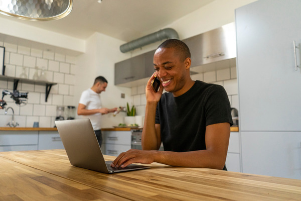 Woman using laptop and cell phone