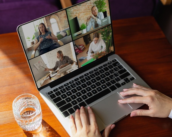 Person using a laptop showing four users on a video call