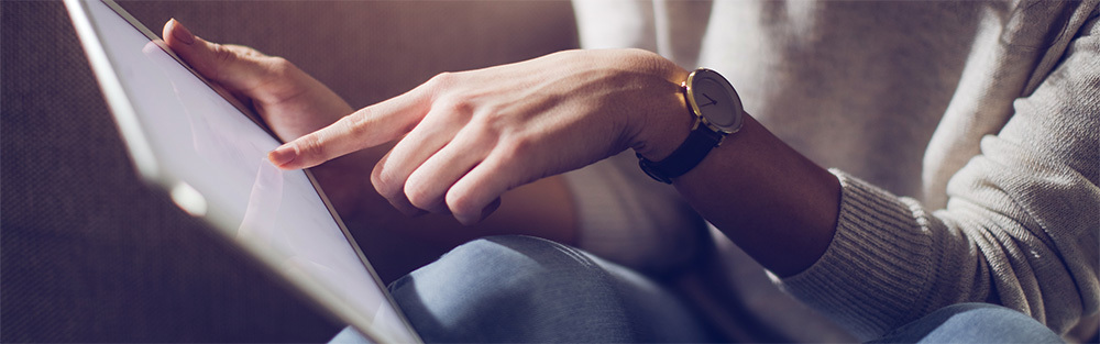 A hand points at a tablet screen