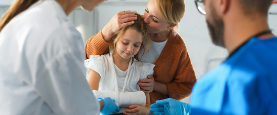 A woman comforts her daughter in a hospital setting. 