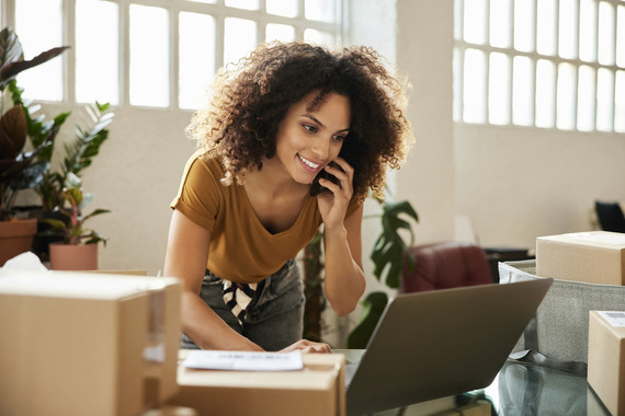 Person using a computer while talking on the phone