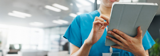 A medical professional uses an electronic tablet in a hospital setting.