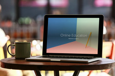 Computer on desk with online education shown on the screen