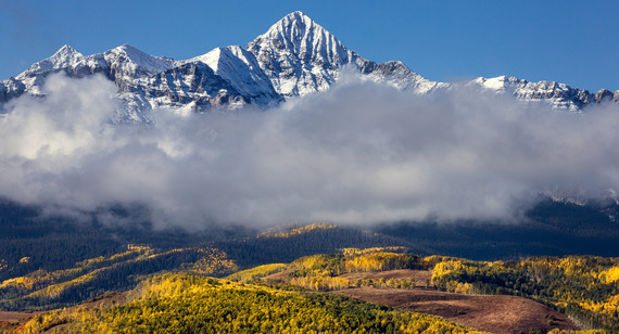 Snow capped mountain peak in fall with cloud cover
