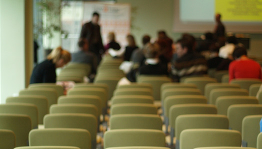 conference room of chairs and people sitting in some of them in the background