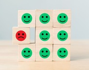 stack of blocks with smile faces on them and one sad face 