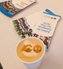 Coffee cup with DORA log in foam on table with flyers