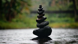 Rocks stacked and balanced on top of each other from largest at the bottom to smallest at the top.