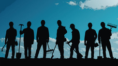 Silhouettes of workers with tools standing in a row against a blue sky.