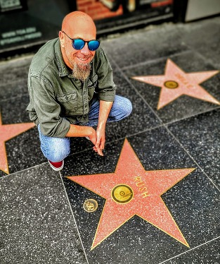 Dan Wilde posing for a photo next to the Rush star on the Hollywood Walk of Fame.