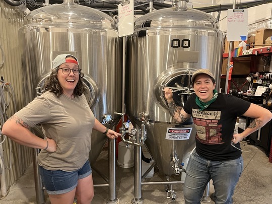 Lady Justice Brewing Owner Betsy and Brewer Meg pointing at the new Spunding Valves