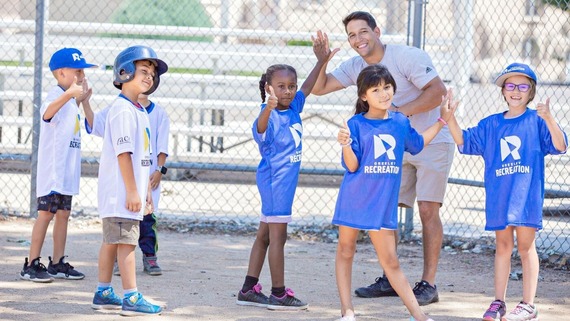 A Greeley Recreation coach offers high fives to his team after a t-ball game