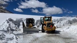 Heavy equipment is used to plow snow from a road near Comanche Reservoir Dam.