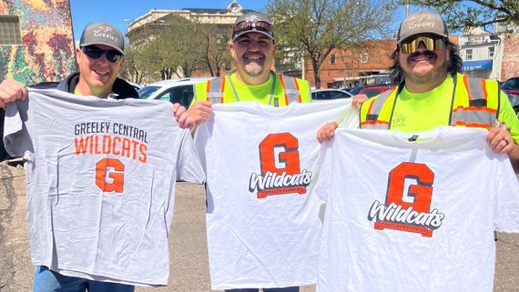 Three members of Greeley Public Works holding up Greeley Central Wildcats shirts