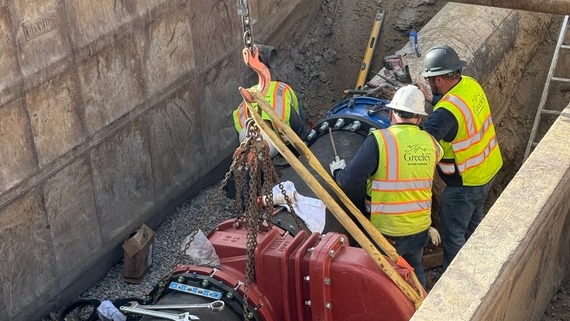 Water and sewer department crews install a valve used to transport drinking water.