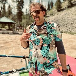Brian Cobb wearing sunglasses and wild shirt, tongue out, giving the hang loose sign