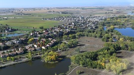 An aerial view of ponds, neighborhoods, and farm land on the west side of Greeley, Colorado, on a sunny day