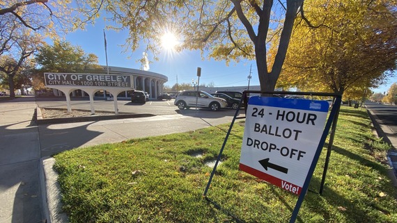 A red-white-and-blue sign outside Greeley City Hall that reads “24-Hour Ballot Drop-off. Vote!”