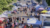 aerial view of street lined with booths and people walking by