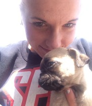 Kylie Jackson, Director of Innovation and High Performance holds a little pug for a selfie.