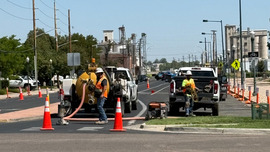 Crews block off a street to perform potholing operations.