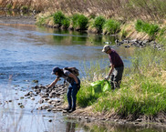 Two volunteers cleaning up a river