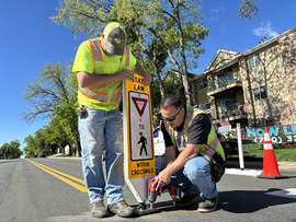Safer Streets crew installing traffic calming crosswalk sign.