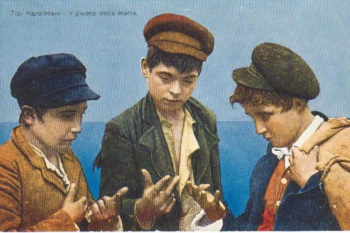 three boys play a game by holding up fingers