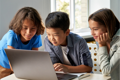 three children look at a computer