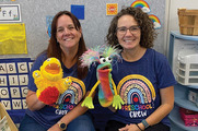 Preschool teachers in classroom holding puppets