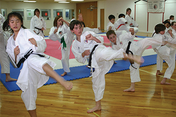 Kids Practicing Karate Kick in Class