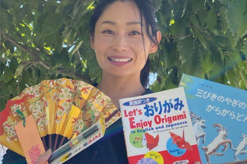 Lady holding up origami book and fan from Japan 