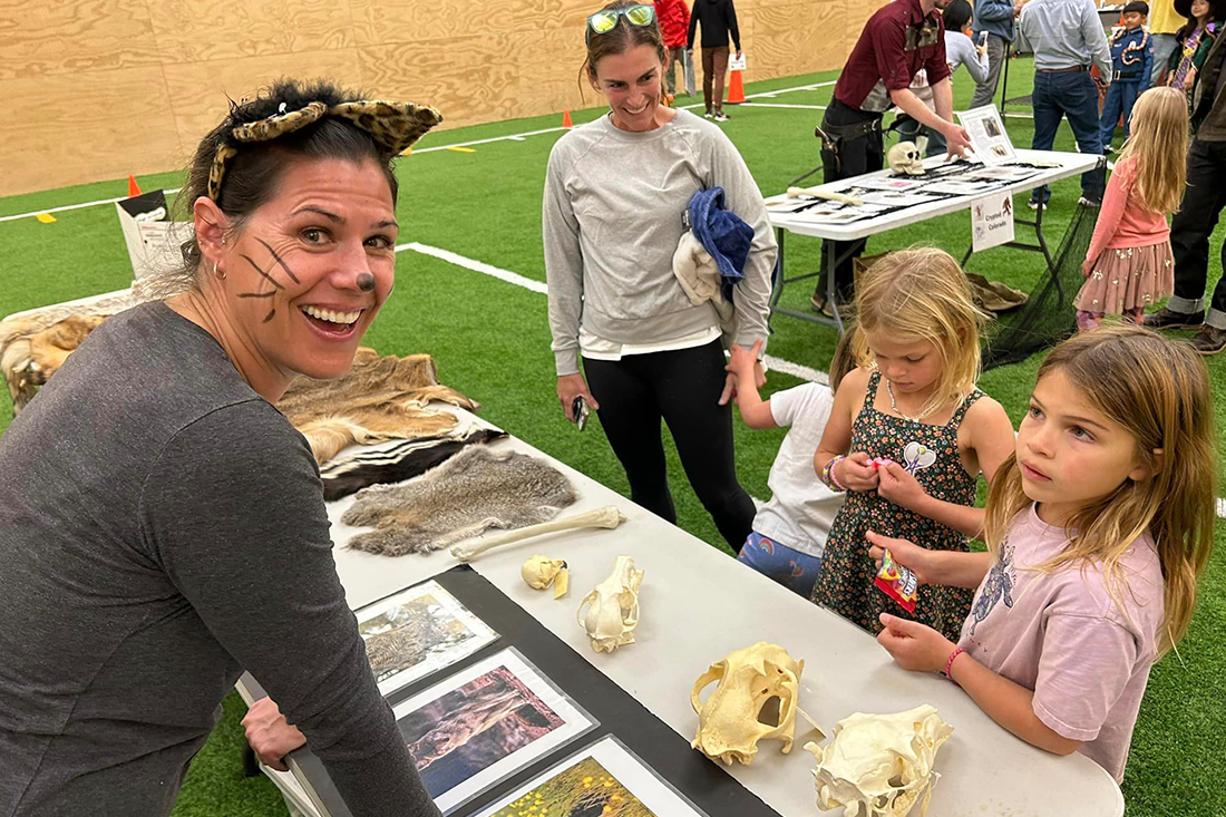 photo of lady showing animal skulls to children for a Halloween event