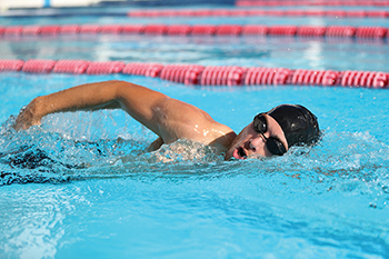 photo of man swimming in pool 