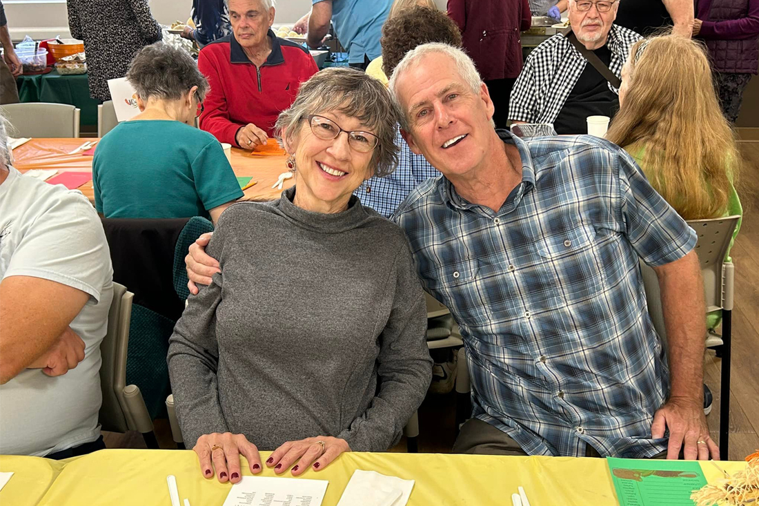 senior man and woman smiling at thanksgiving event