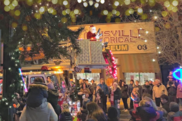 a crowd in the dark gather around the Louisville Historical Museum, a Santa figure is on a fire truck as part of a parade