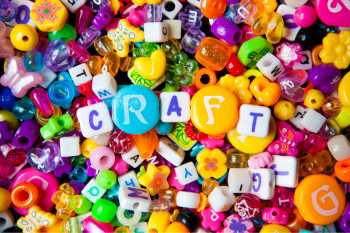 pile of colorful beads with beads that spell out "craft" in the center