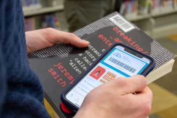 library user using phone to checkout book