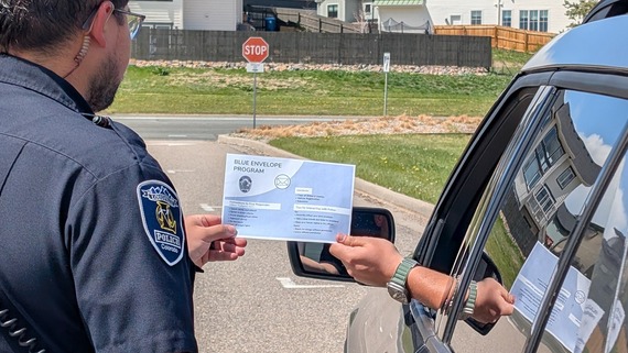 Driver handing officer Blue Envelope