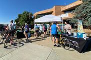 Cyclists gathered around tables in front of Louisville City Hall during Bike to Work Day 2024