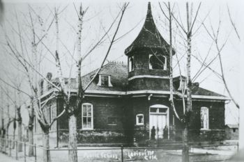 Black and white photograph of 801 Grant Avenue. It is a brick schoolhouse with a bell gable.