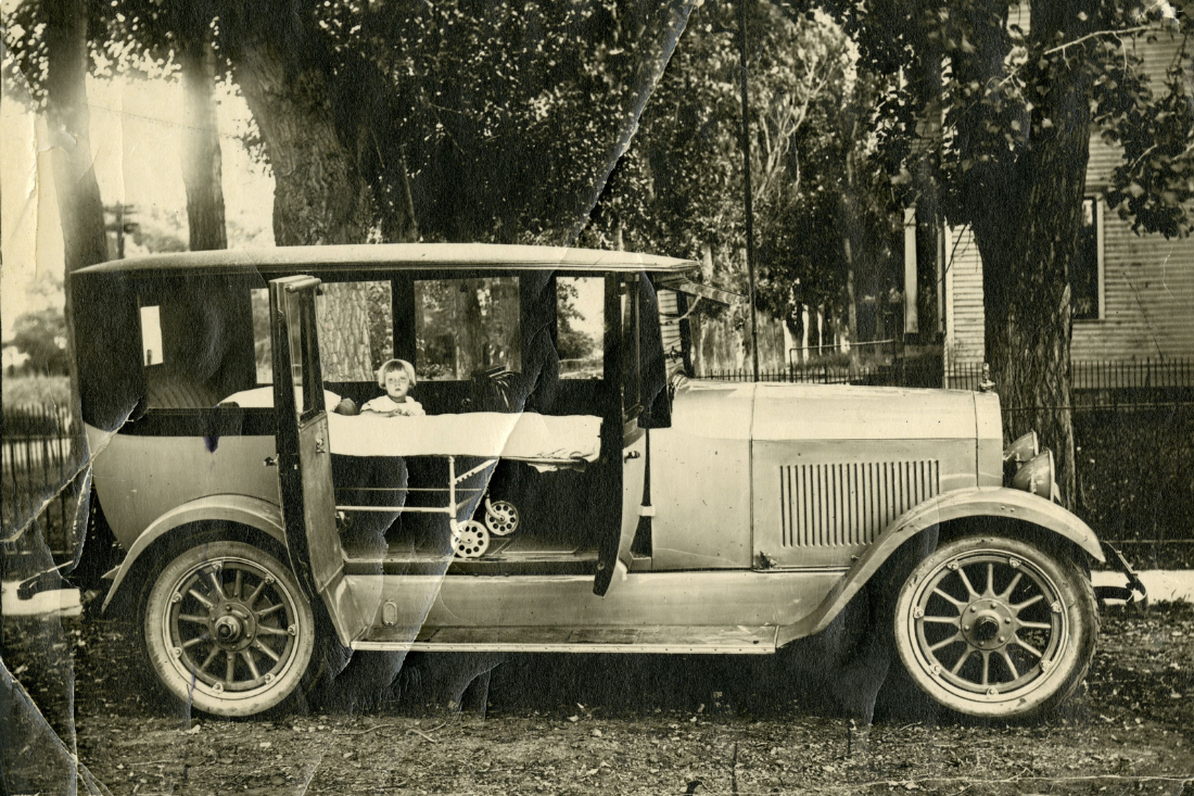 Photo of Blossom Henning standing in the back of George Henning's ambulance car in 1924.
