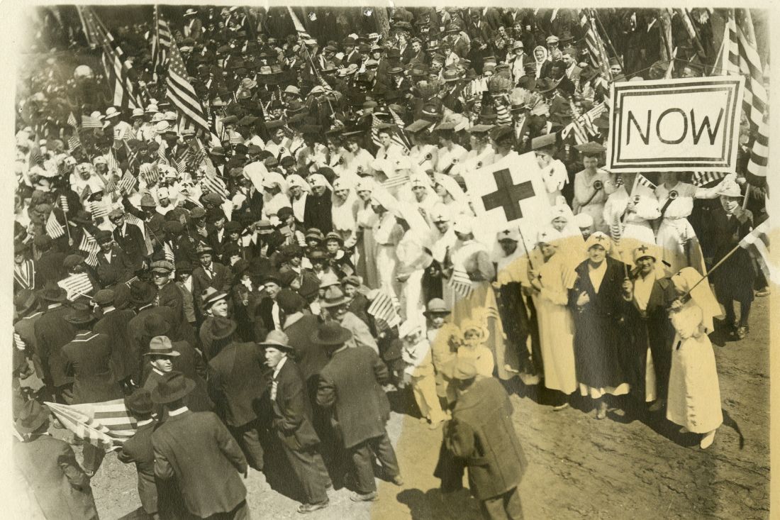 Crowd of men, women, and children gathered for a parade to support WWI war bonds.