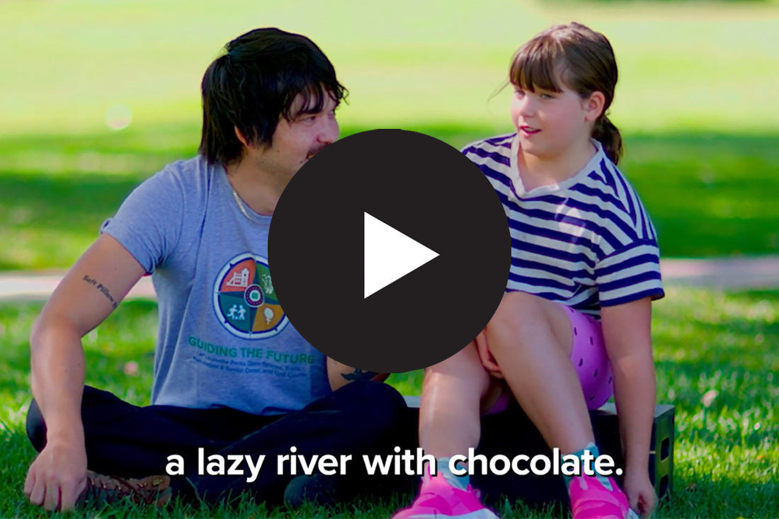 A person interviewing a kid with a play button overlayed