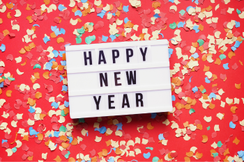 sign "happy new year" on background of party confetti