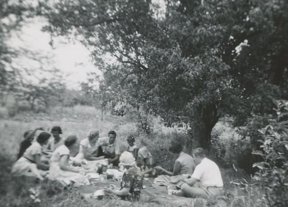 The Bowes family and friends picnicking in an orchard of apple and pear trees