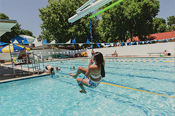 Kid on zipline at outdoor pool 
